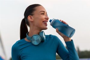 Mulher segurando uma garrafa de água olhando para frente